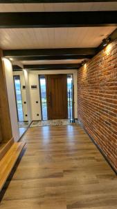 una stanza vuota con un muro di mattoni e una porta di GORF House a Krapivnik