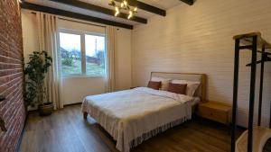 ein Schlafzimmer mit einem Bett und einem großen Fenster in der Unterkunft GORF House in Krapivnik