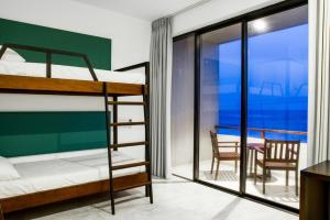 a bedroom with bunk beds and a dining room with a balcony at Linará in Hikkaduwa