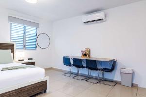 Un dormitorio con una cama y una mesa con dos sillas azules. en Aquaville Dorado Moderna Studio 6, en Dorado 21 fotos más