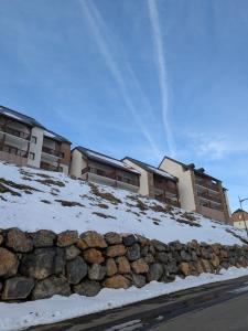 Un cocon en plein cœur de la Mongie في لا مونجي: جدار حجري احتياطي أمام بعض المباني +9 صور