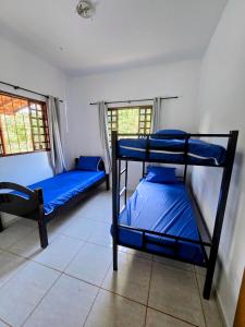 dois beliches em um quarto com lençóis azuis em Chácara com piscina e lago aconchegantes em Planaltina