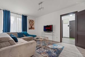 een woonkamer met een bank en een tv bij Stylish Blue Haven 1 BR Balcony Access in Boekarest