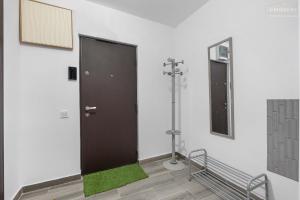 een deur in een kamer met een groen tapijt en een spiegel bij Stylish Blue Haven 1 BR Balcony Access in Boekarest +19 foto's