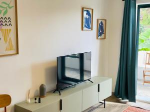a living room with a tv on a white cabinet at Sunny Escape - Ponta do Sol - Vila Silva Downstairs in Ponta do Sol