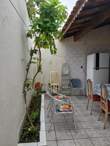 大普拉亚Casa pé na areia 40 metros da praia Caiçara的露台上有椅子、树和冰箱