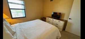 Ocean Terrace في Daytona Beach Shores: غرفة نوم بسرير ونافذة وخزانة +4 صور