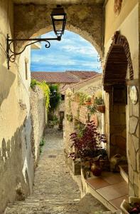 an alley with an archway in a stone building at Attico con vista unica in Scalea