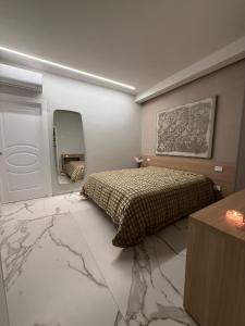 a bedroom with a bed and a mirror and marble floor at Porta Bari Rooms in Altamura