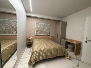 a bedroom with two beds and a painting on the wall at Porta Bari Rooms in Altamura