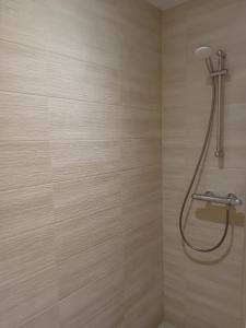 a bathroom with a shower with a hose on the wall at Au nid du colibri in Somme-Leuze