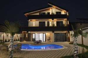 a villa with a swimming pool at night at Davos Hotel in Pʼarakʼar