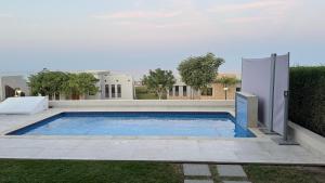 a swimming pool in the backyard of a house at The Pearl villa sifah muscat in As Sīfah