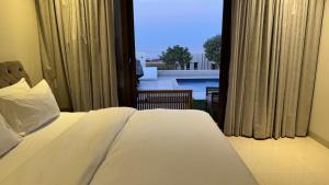 a bedroom with a bed and a view of a pool at The Pearl villa sifah muscat in As Sīfah