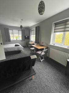 a bedroom with a bed and a desk and a table at Happy Airfield Studio in Sandtoft