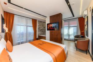 a hotel room with a bed and a flat screen tv at Elysian Airport Hotel & Restaurant in Arnavutköy
