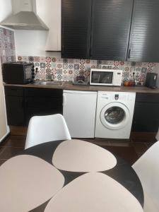 a kitchen with a washing machine and a microwave at Ferienhaus David in Pinkafeld