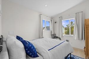 una camera da letto con un letto con cuscini blu e due finestre di Seaside Getaway A a Seaside