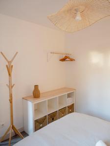 a bedroom with a bed and a shelf and a fan at La Cabane 21, Maison, Andernos-Les-Bains in Andernos-les-Bains
