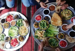 a table with a bunch of plates of food at White desert Safari tent in Aweina