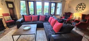 a living room with a large couch with red pillows at The Waltzing Weasel in Birch Vale