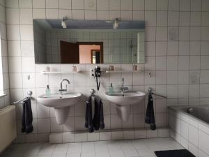 a bathroom with two sinks and a mirror and a tub at Ferienwohnung "Tilda" auf Hof Elseblick in Bünde