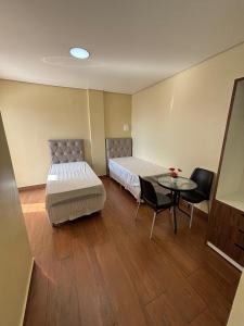 Un dormitorio con una cama y una mesa y sillas. en Sumaúma Hotel, en Tefé