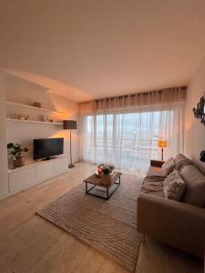 a living room with a couch and a large window at Studio in Wenduine with frontal sea view in Mellet