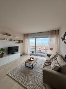 a living room with a couch and a view of the ocean at Studio in Wenduine with frontal sea view in Mellet