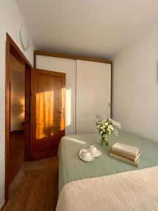 a bedroom with a bed with a vase of flowers and books at Attico con vista unica in Scalea