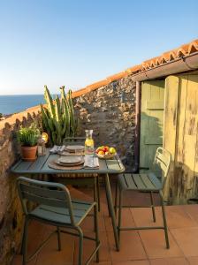 a table and chairs on a patio with the ocean at Attico con vista unica in Scalea