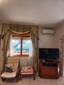 Una sala de estar con televisión y una ventana. en Casa di Viaggiatori Ciampino, en Ciampino 11 fotos más