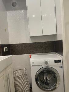 una lavatrice in una cucina con armadietto bianco di Spacious apartment with a beautiful view a Căuşeni