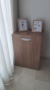 Ein Holzschrank mit zwei Kisten darauf neben einem Fenster in der Unterkunft City Chic stade&centre Princesse in Casablanca