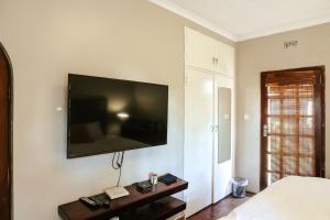 a bedroom with a large television on the wall at Borrowdale Hearthside Retreat in Harare +15 photos