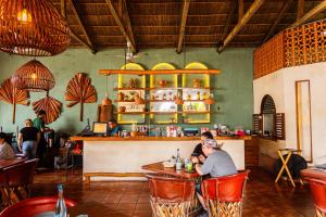two people sitting at a bar in a restaurant at La Posada Hotel Boutique in Manzanillo