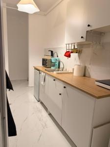 eine Küche mit weißen Schränken und einer Holzarbeitsplatte in der Unterkunft DreamStay Militari Residence in Roşu