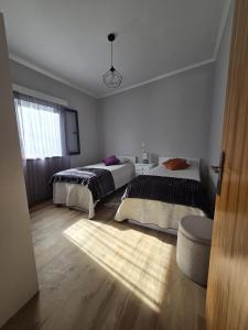 ein Schlafzimmer mit zwei Betten und einem Fenster in der Unterkunft Casa Rosa in Porto da Cruz
