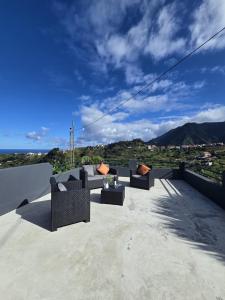 eine Terrasse mit Sofas auf einem Dach in der Unterkunft Casa Rosa in Porto da Cruz