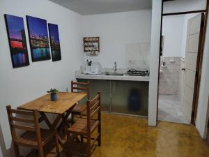 a kitchen and dining room with a wooden table and chairs at Kaihalulu Beach Room - Punta Hermosa in Punta Hermosa