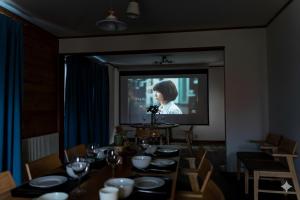 a dining room with a television and a table with chairs at Cloud9 Toya in Lake Toya