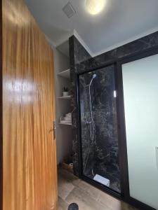 ein Badezimmer mit Dusche und Glastür in der Unterkunft Casa Rosa in Porto da Cruz