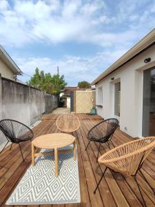 eine Terrasse mit zwei Tischen und Stühlen auf einem Holzdeck in der Unterkunft Chambre privée -Pessac-Modern BR1-1 in Pessac