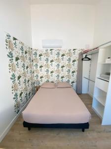 ein kleines Schlafzimmer mit einem Bett und einem Kühlschrank in der Unterkunft Chambre privée -Pessac-Modern BR1-1 in Pessac