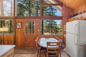 una cucina con un tavolo e un frigorifero bianco di Mountain Getaway - Stunning Views a Pine Mountain Club