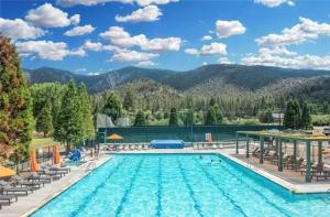 una piscina con sedie e una montagna sullo sfondo di Mountain Getaway - Stunning Views a Pine Mountain Club