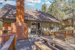una casa con un terrazzo con una panca e un camino di Mountain Getaway - Stunning Views a Pine Mountain Club
