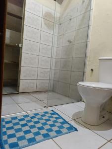 a bathroom with a toilet and a shower with a blue rug at Hostel IndiaJara in Itacaré +27 photos
