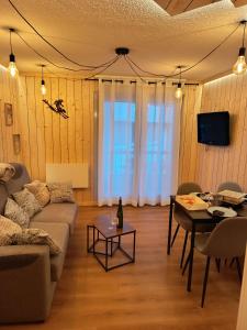 ein Wohnzimmer mit Sofa und Tisch in der Unterkunft Le nid de l'isard, draps et serviettes fournies in Cauterets + 16 Fotos