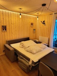Bett in einem Zimmer mit holzgetäfelten Wänden in der Unterkunft Le nid de l'isard, draps et serviettes fournies in Cauterets